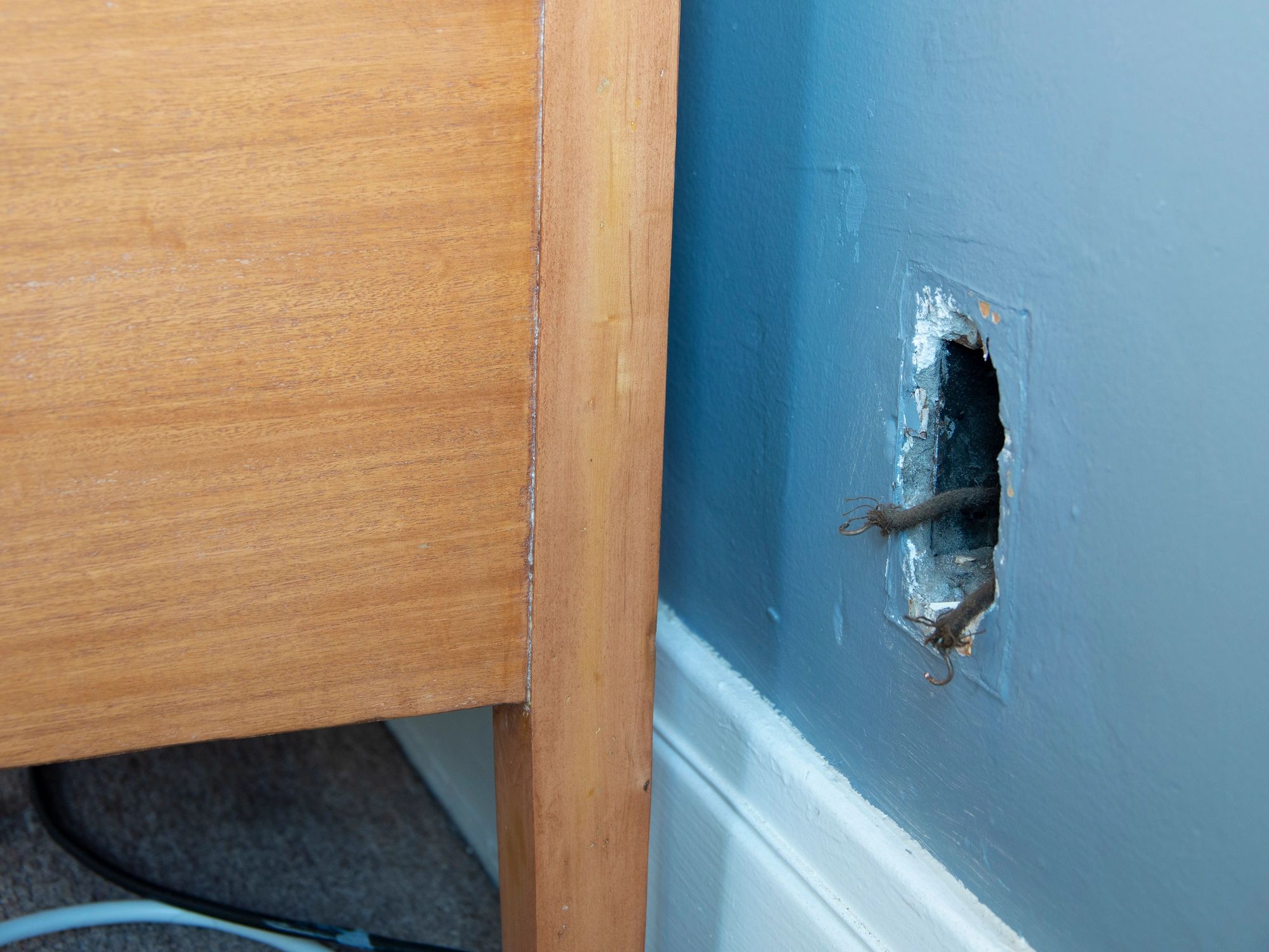 Exposed wiring at a missing electrical outlet during repair